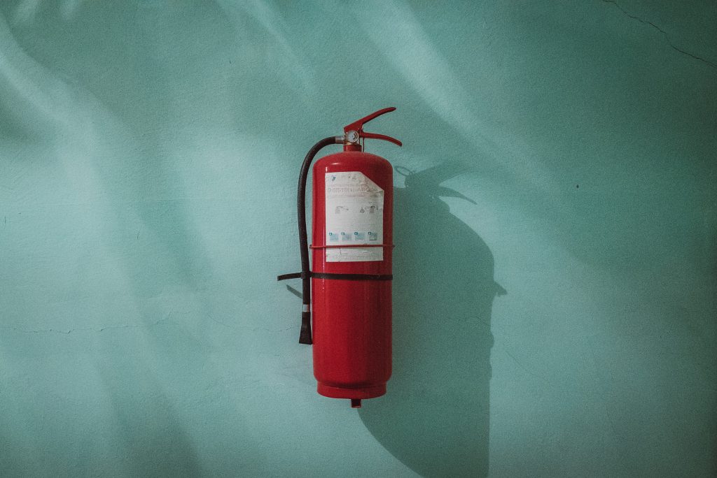 Fire extinguisher mounted on a blue wall.