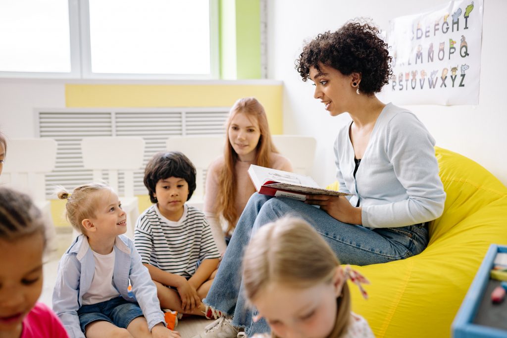 An adult reading a book to a group of children.